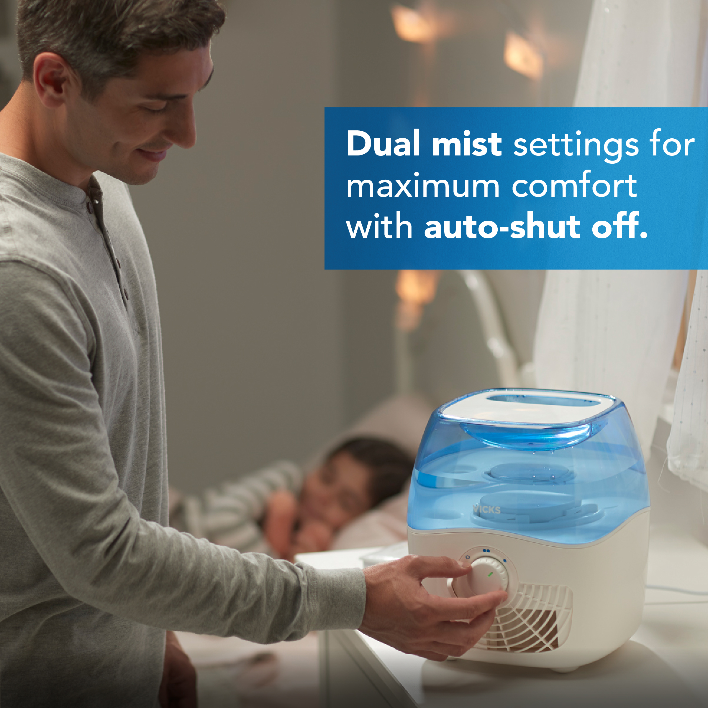 A father adjusting a mist output level on Vicks Filtered Cool Mist Humidifier in his daughter's room with text Dual mist settings for maximum comfort with auto-shut off