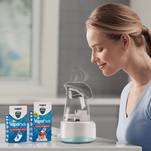 Woman inhaling from a Vicks Personal Steam Inhaler