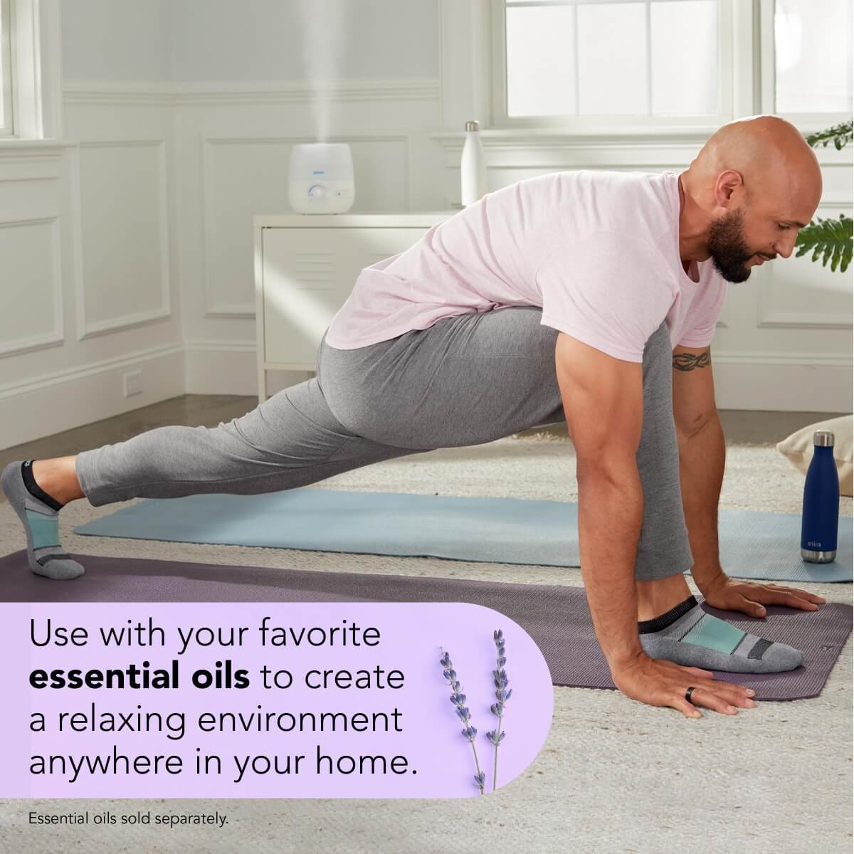 A relaxed man practicing yoga in a small room with cool mist released from Vicks NaturalCare™ Cool Mist Ultrasonic Humidifier, with text Use with your favorite essential oils to create a relaxing environment anywhere in your home