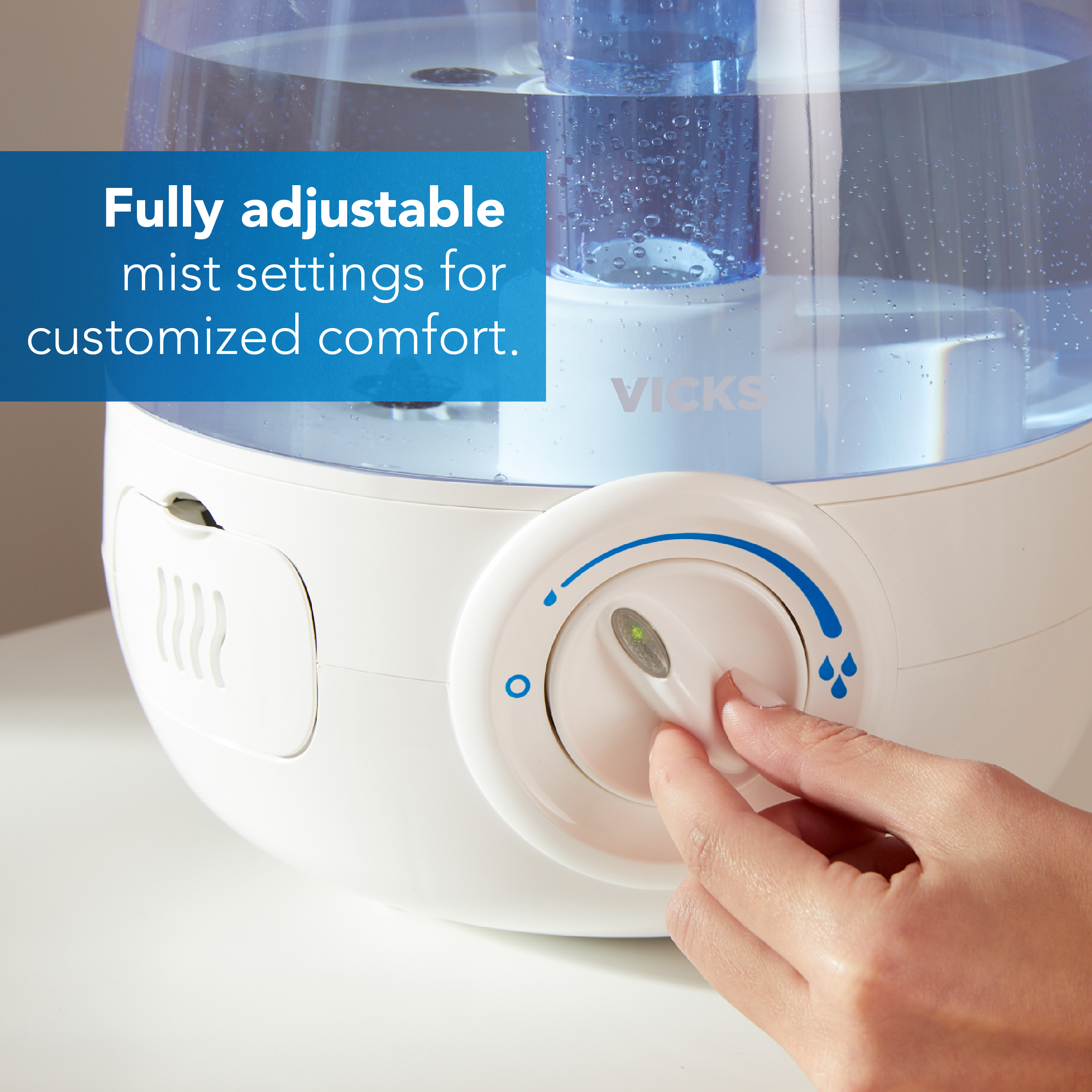 A hand adjusting the mist output level on the Vicks Cool Mist humidifier with text Fully adjustable mist setting for customized comfort